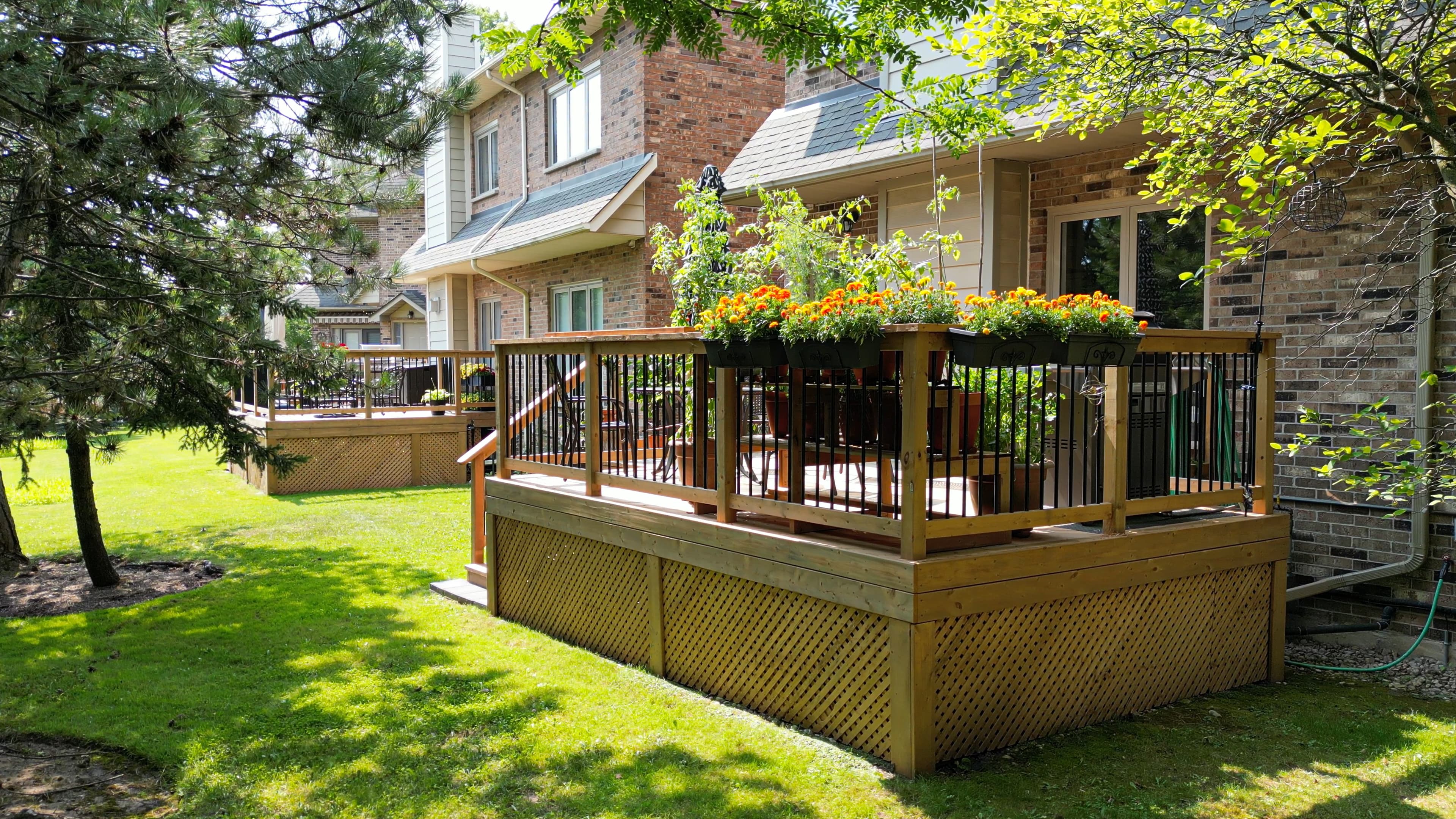 Full view of pressure treated deck with lattice skirting and landscaped backyard